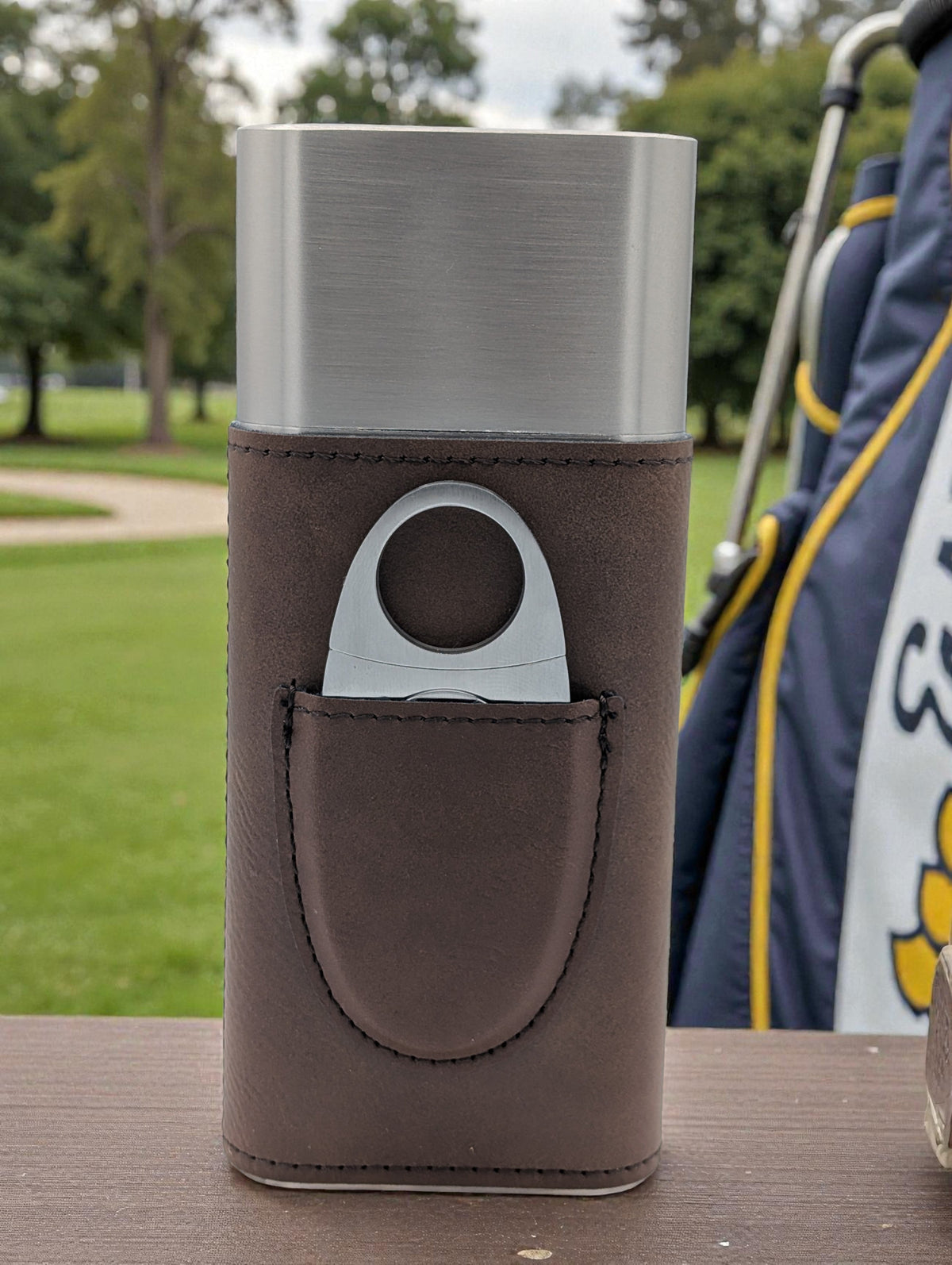 Brown leather Triple-Threat Cigar Case holding three cigars, designed for travel and protection.