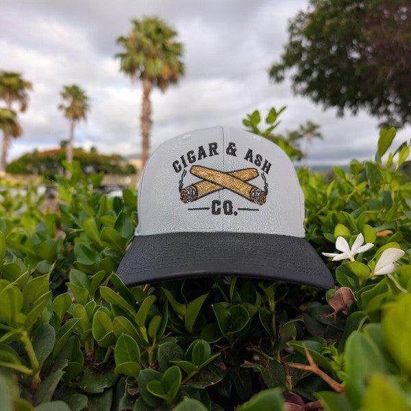 Detailed front view of breathable perforated snapback hat with embroidered Cigar & Ash Co. logo