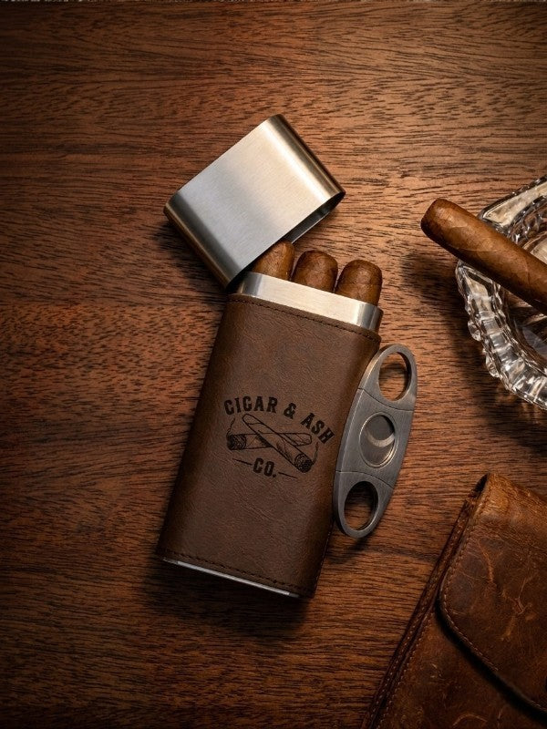 Cigar & Ash Co. Triple Threat travel cigar case with stainless steel lid holding three cigars on a wooden table